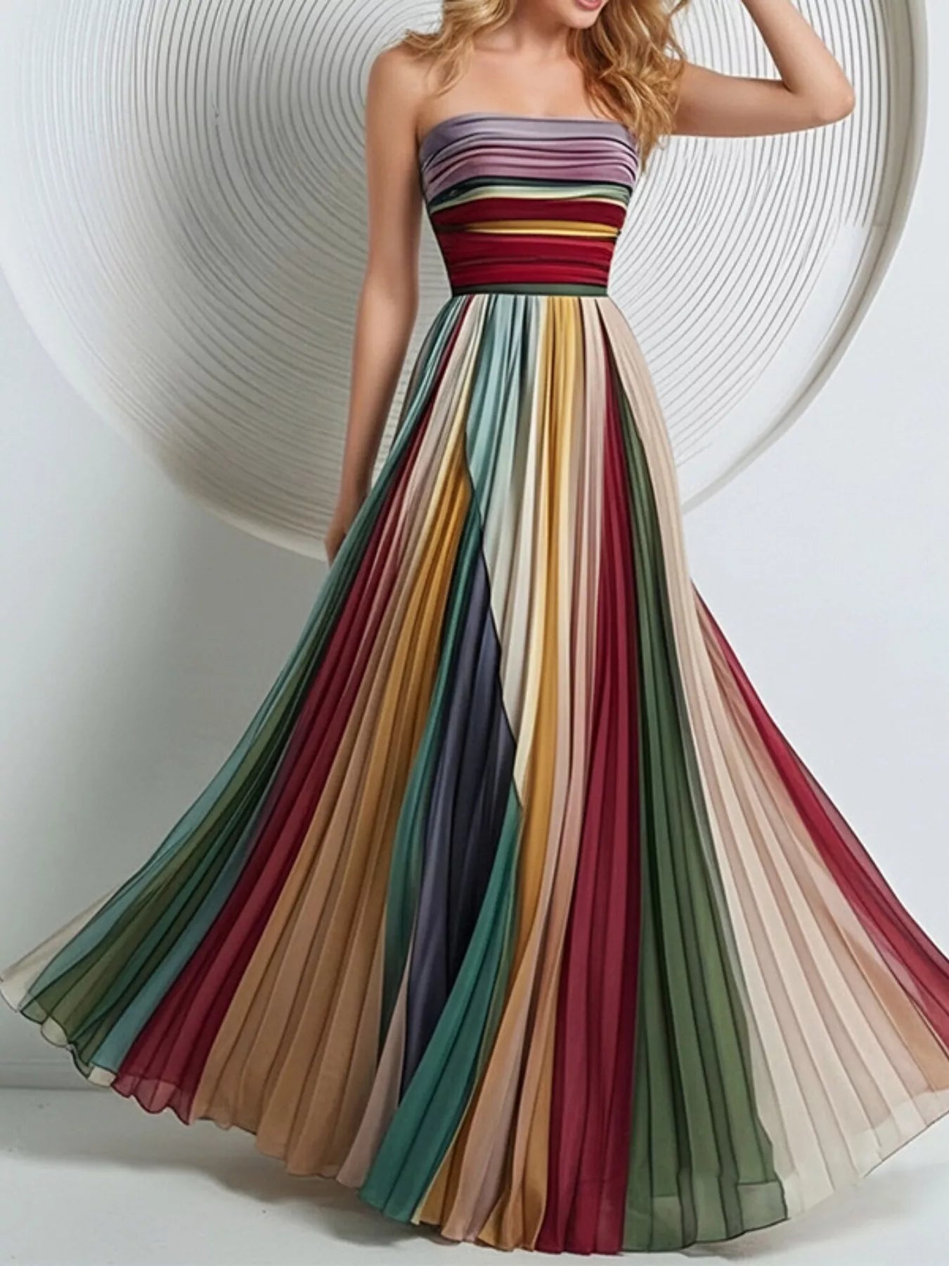 Model wearing the Striped Pleated Tube Maxi Dress in multicolor stripe, front view with the skirt lifted to one side to show the vertical pleating and A-line sweep.