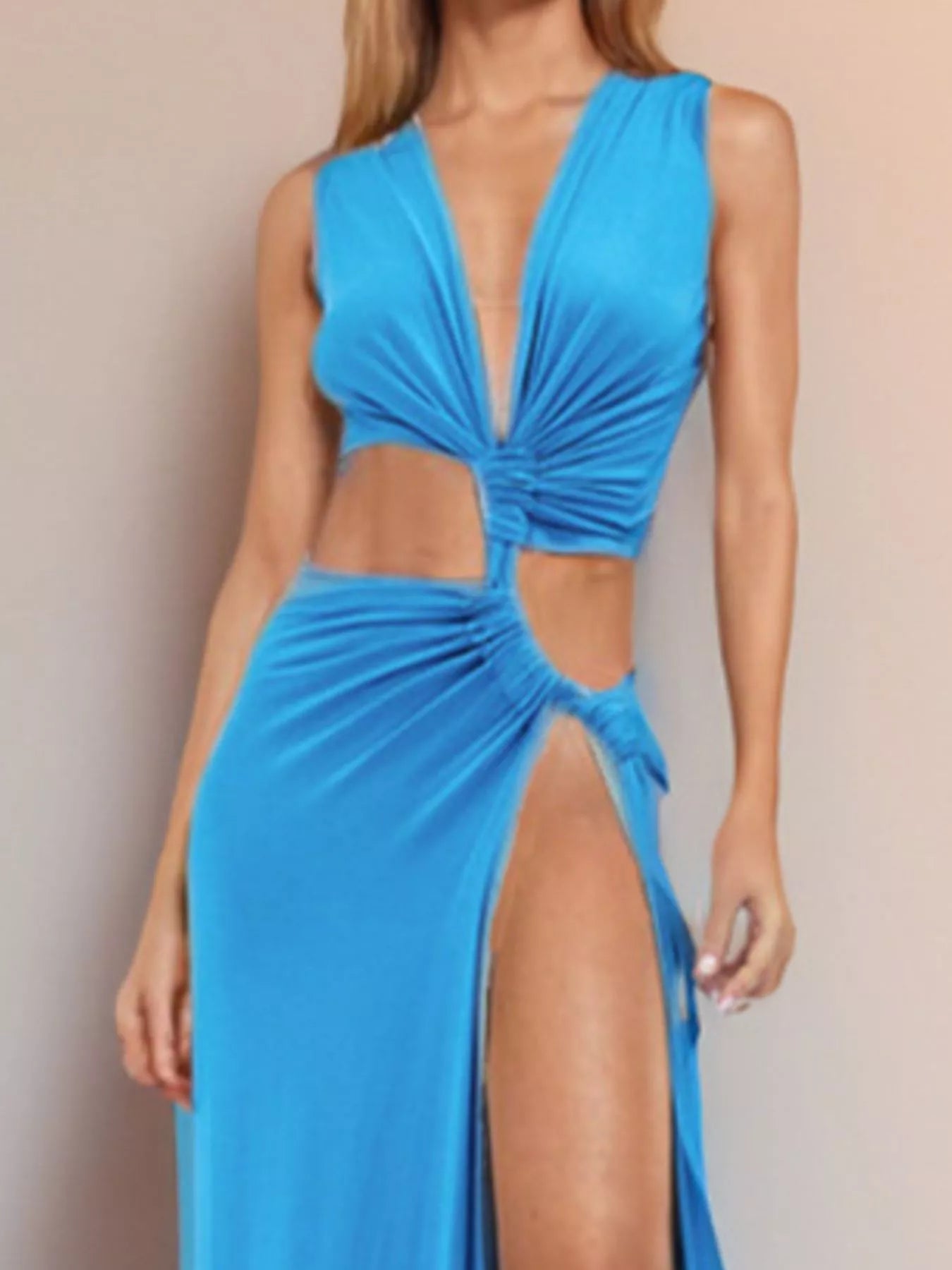 Cobalt blue plunge V-neck cutout maxi dress, closer mid-body crop in studio, showing the deep V neckline, twisted center knot, asymmetric side cutout, and high thigh slit.
