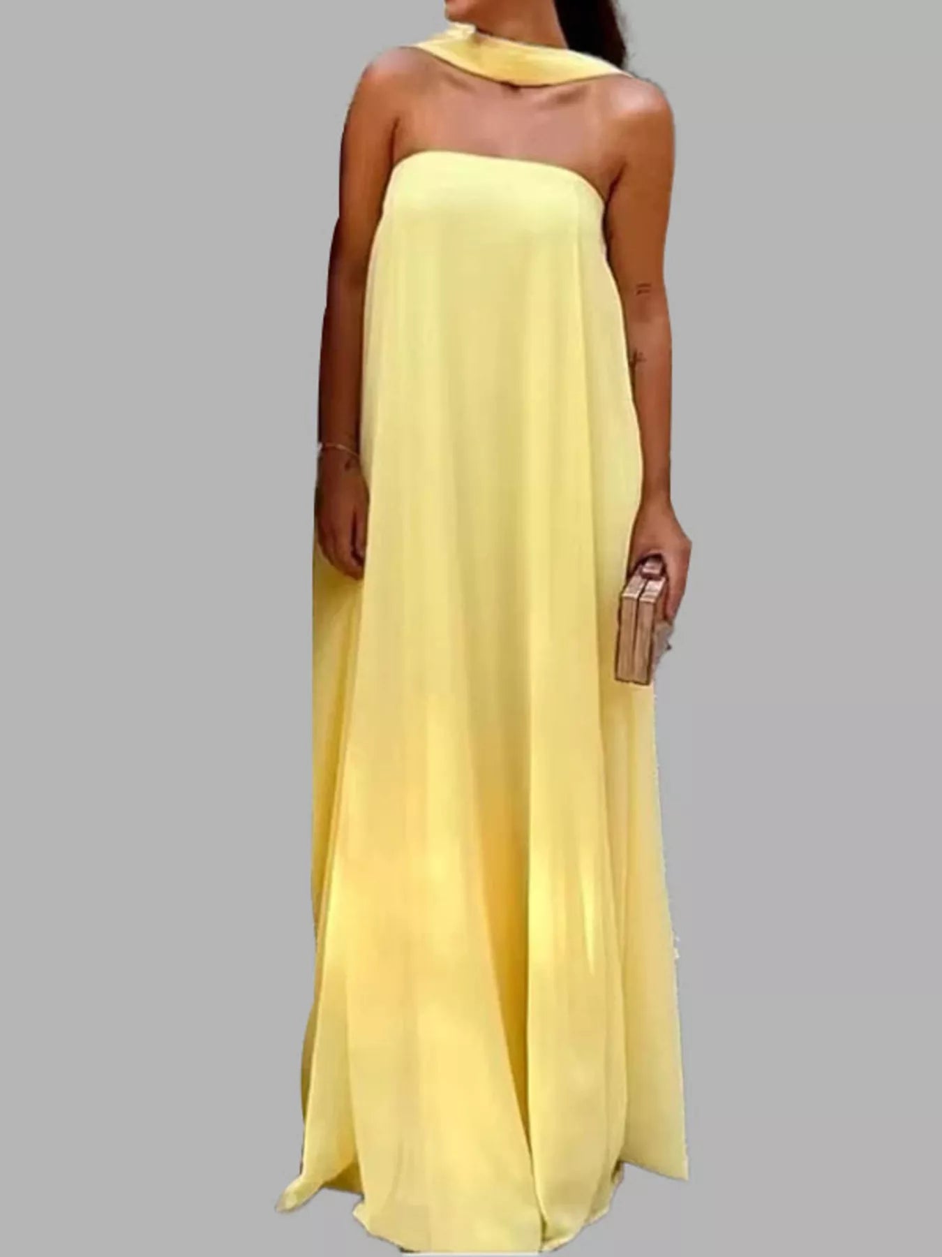 Front view of woman wearing a butter yellow draped halter scarf neck maxi dress with flowing A-line silhouette