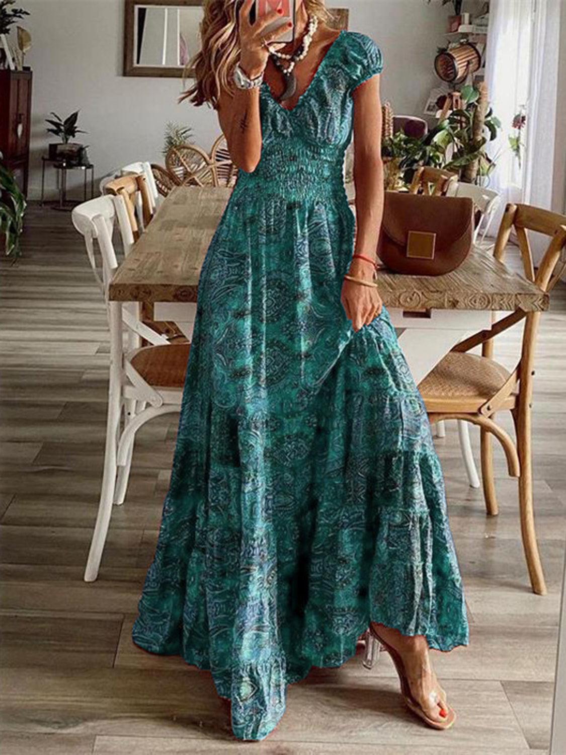 Blue paisley smocked V-neck short-sleeve maxi dress, front view showing the smocked bodice and tiered floor-length skirt.