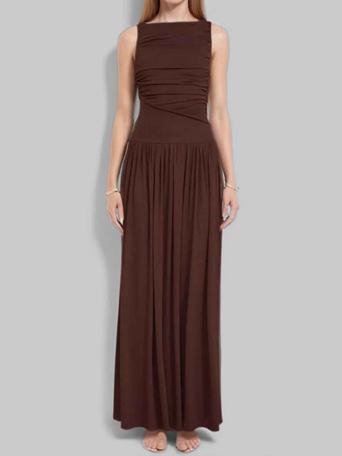 Brown ruched bodice drop-waist sleeveless maxi dress, full-length front view showing the asymmetric ruching and full gathered skirt.