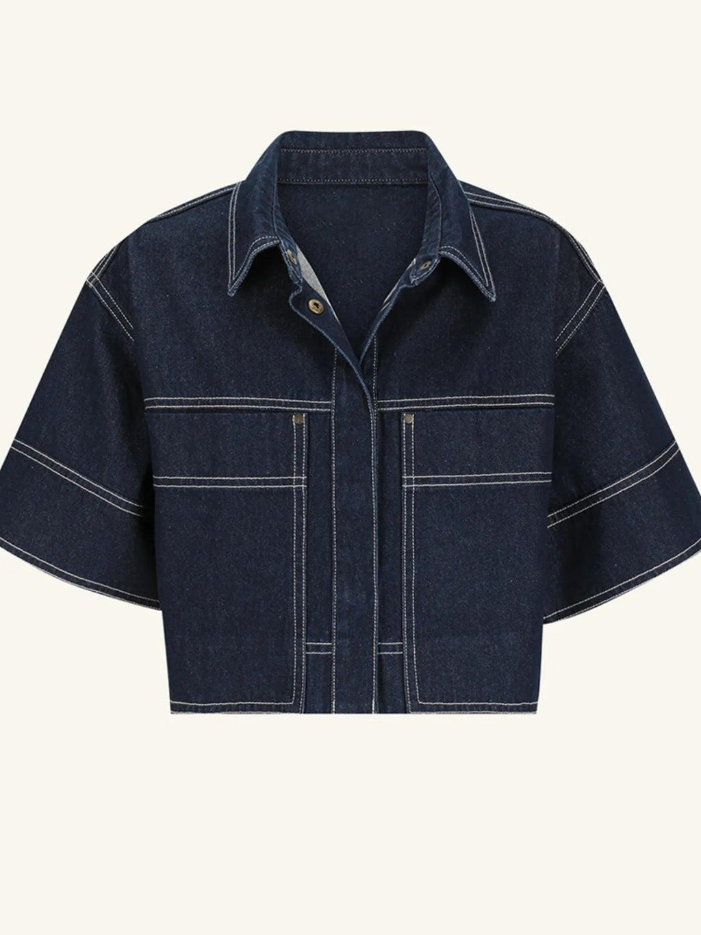 Midnight blue cropped denim top, mid-body detail showing the contrast white topstitching tracing the seams, pockets, and placket.