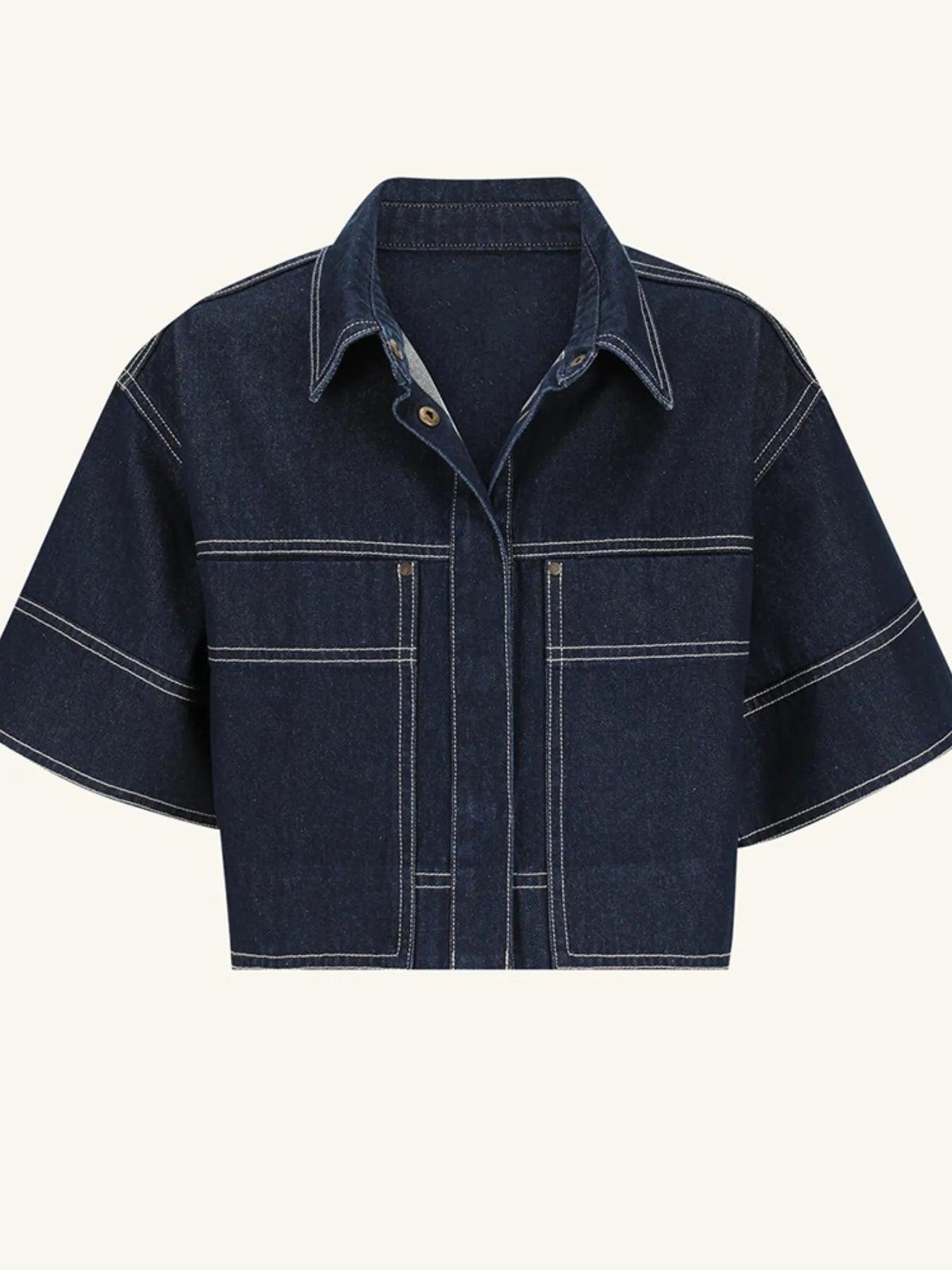 Midnight blue cropped denim top, mid-body detail showing the contrast white topstitching tracing the seams, pockets, and placket.