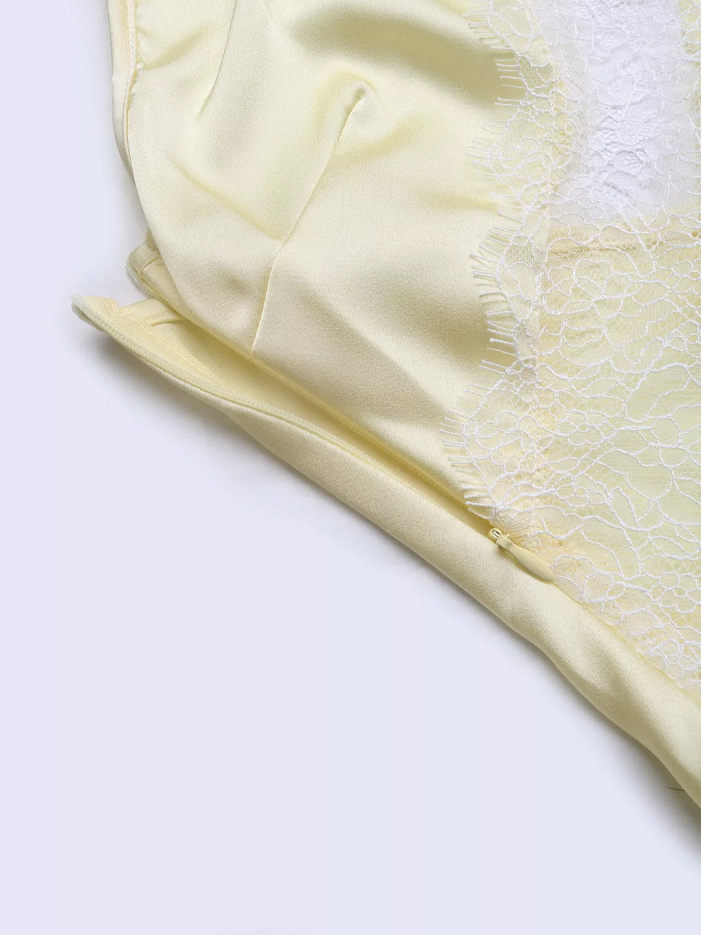 Close-up of the lace-trimmed edge of the Pastel Yellow Lace-Trim Slip Midi Dress, showing the eyelash lace finish against the satin fabric.