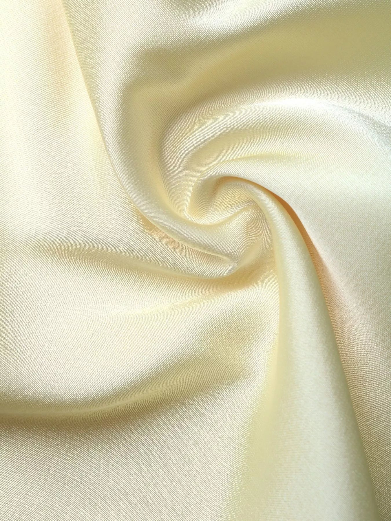 Close-up of the pastel yellow satin fabric used in the Pastel Yellow Lace-Trim Slip Midi Dress, showing the soft drape and natural sheen.
