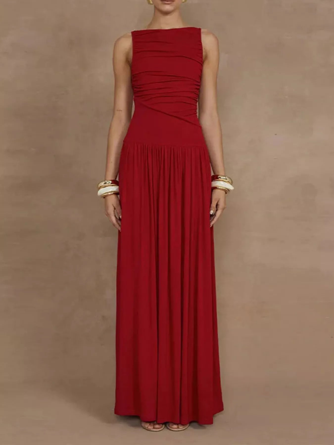 Red ruched bodice drop-waist sleeveless maxi dress, full-length front view showing the asymmetric ruching across the bust and waist with the full gathered skirt.
