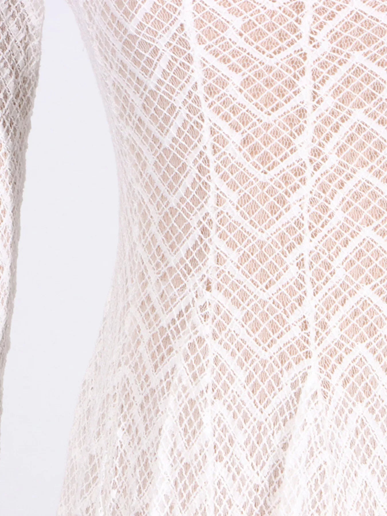 White lace mock-neck maxi dress, hem detail showing the open-knit lace and slight flare at the floor.