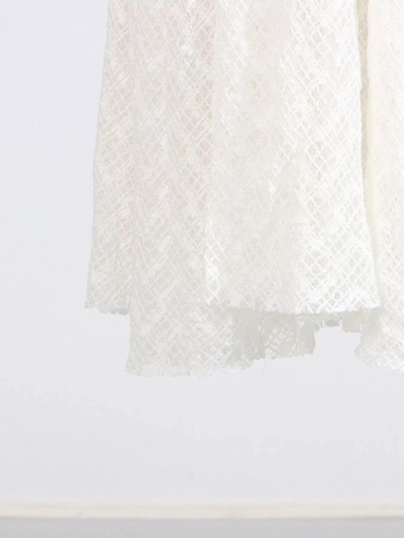 White lace mock-neck long-sleeve maxi dress, fabric and texture close-up showing the open-knit lace.
