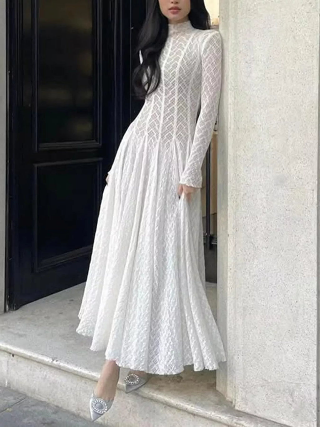 White lace mock-neck maxi dress, three-quarter view showing the high mock neckline and long fluted sleeves.