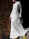 White textured lace mock-neck long-sleeve maxi dress, full-length front view against dark wood doors, styled with a quilted gray top-handle bag.